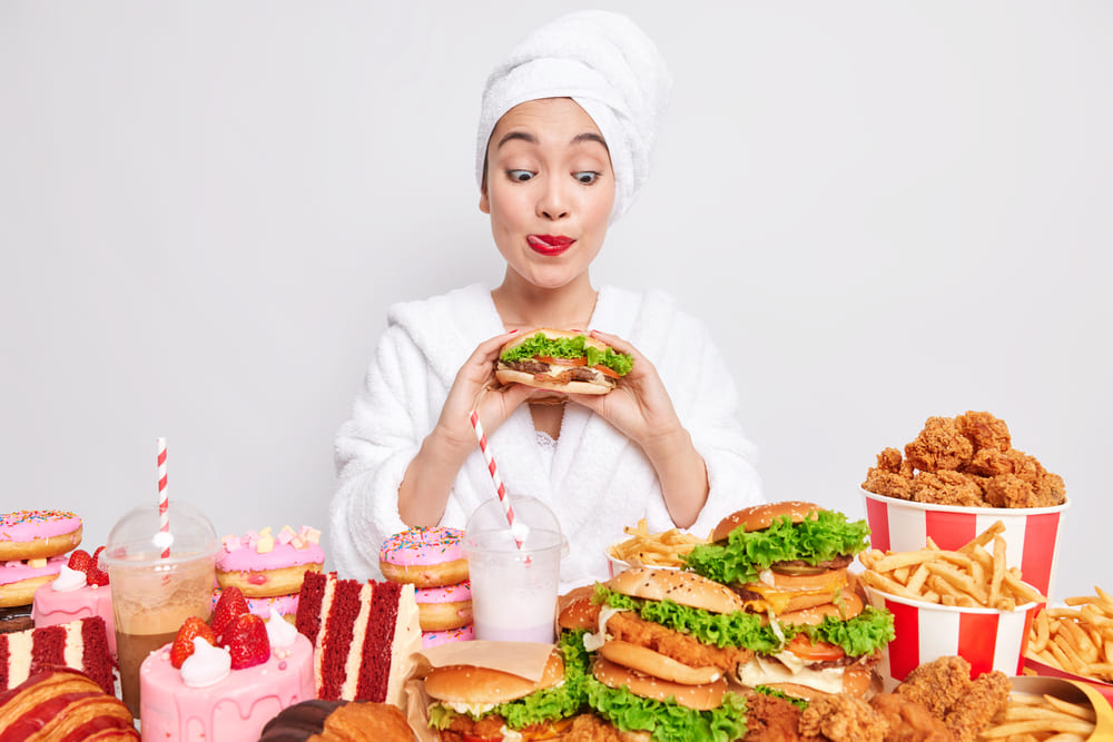 Mulher comendo alimentos não saudáveis