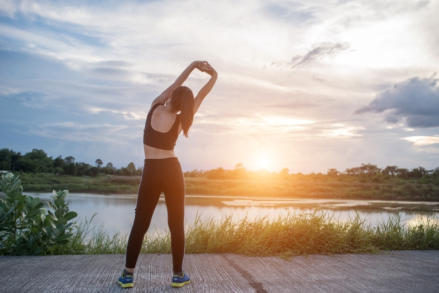 Mulher se alongando em prática de exercícios