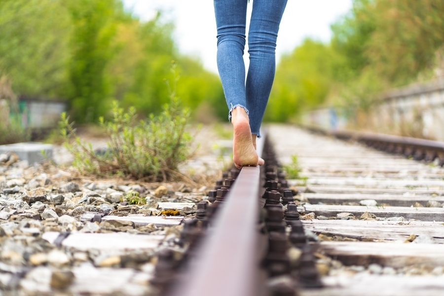 Mulher andando descalço e uma trilha